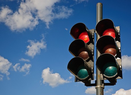 A couple of red traffic lights against a blue sky